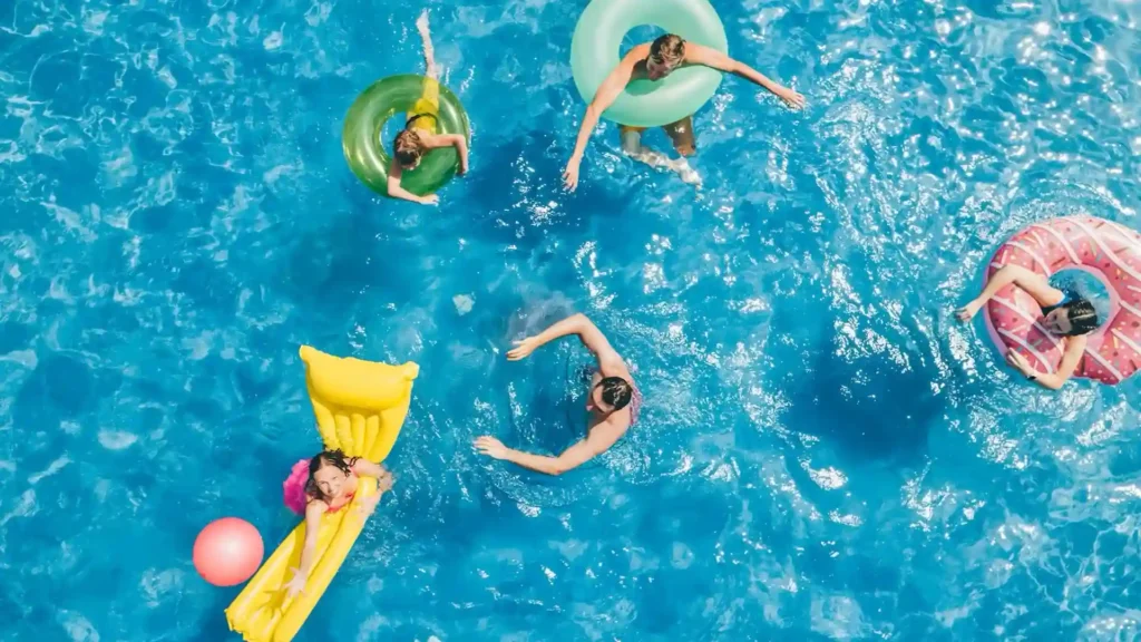People floating in a crowded pool, a common source of pool flu from contaminated water