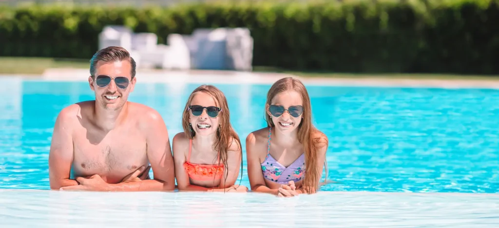 A smiling family of four enjoying time together in a modern automated pool
