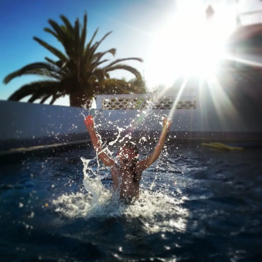 Happy child playing and splashing in a sunny Orlando Florida family pool