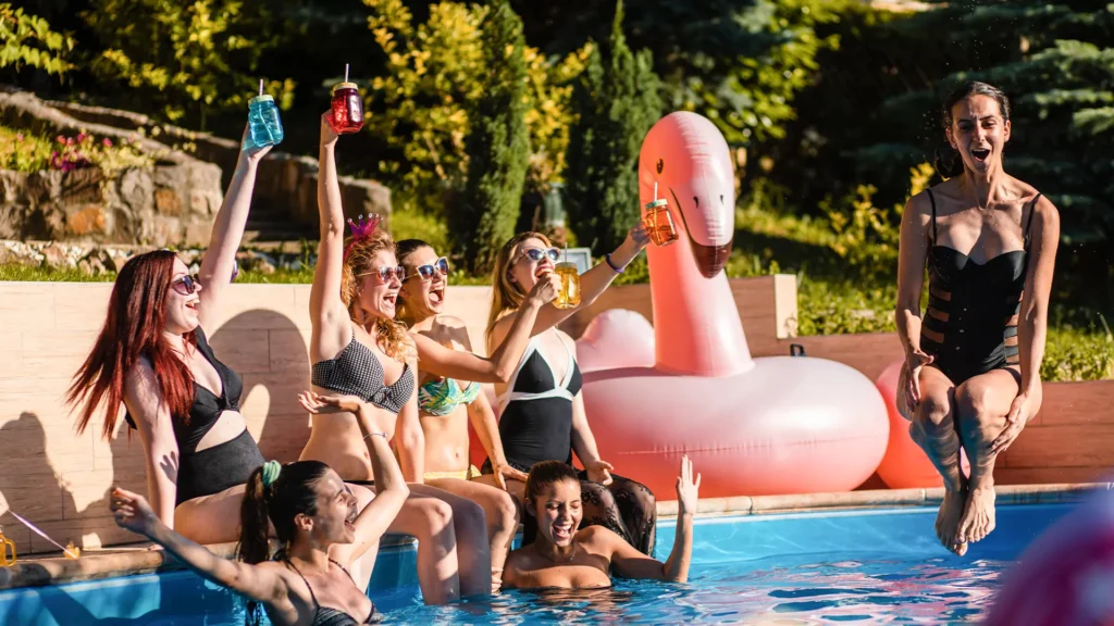 Residential Miami pool party with friends relaxing and swimming in a backyard pool