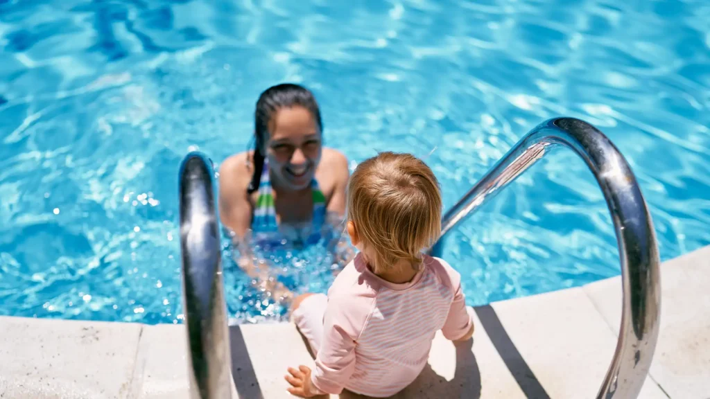 A mother in Port Charlotte supervises her young child playing safely in a crystal-clear, well-maintained swimming pool.