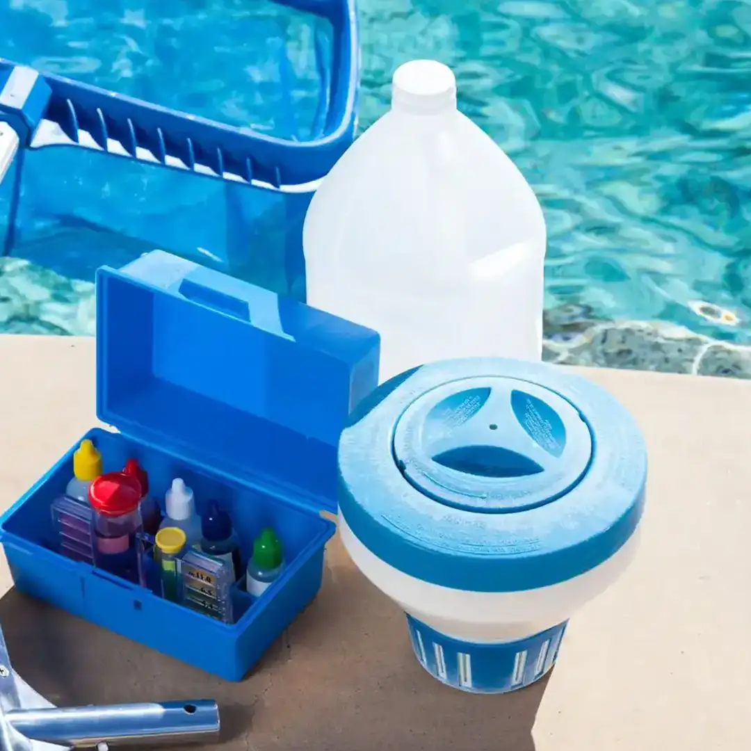 A complete set of professional pool cleaning equipment, including brushes, pH testing kits, and chemical bottles, arranged neatly beside a sparkling clean swimming pool.