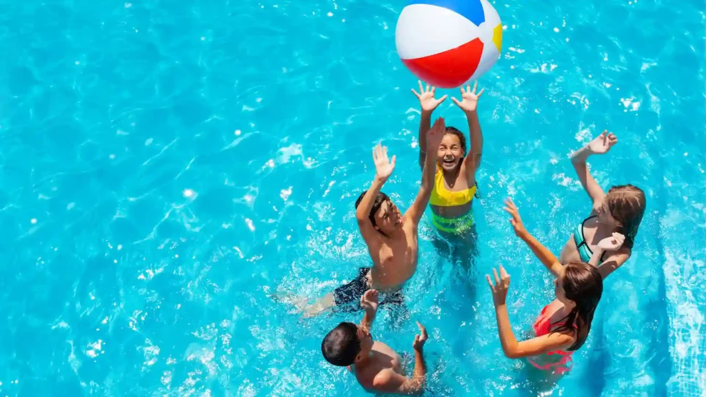Group of kids playing the classic pool game Marco Polo in a swimming pool