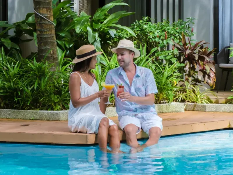 A vacation couple enjoying a clean and refreshing pool, maintained by professional pool cleaning services near me