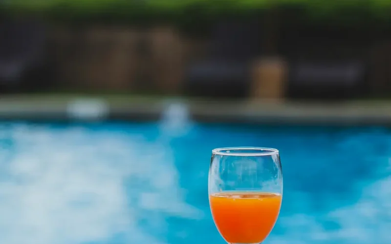 A stylish commercial pool bordered by sunglasses and a refreshing cocktail, perfect for Miami’s vibrant vibe