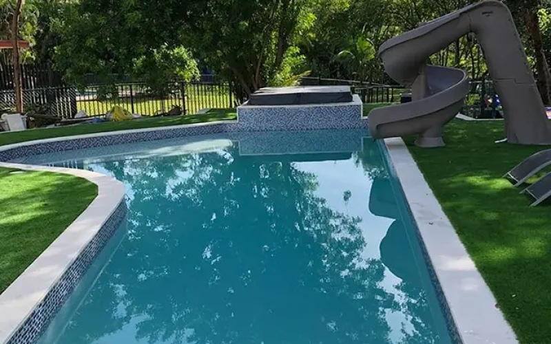 Backyard pool with an added slide for family fun